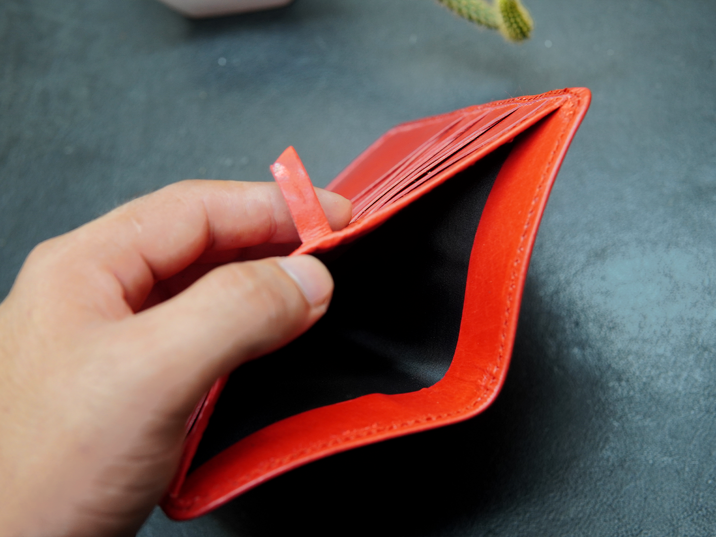 Hand holding an open red wallet
