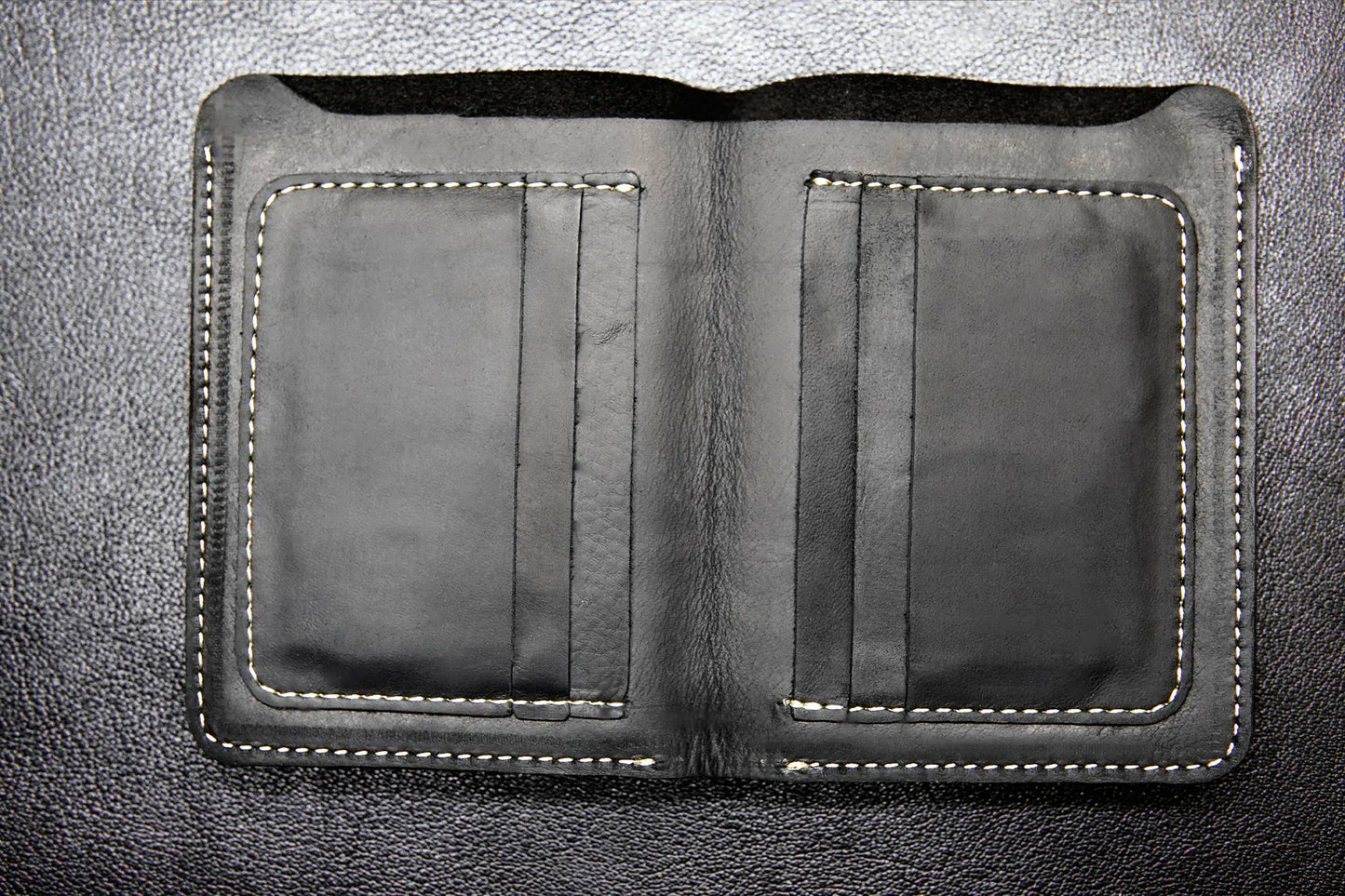 Black passport-size leather wallet with 6 card slots and a cash compartment