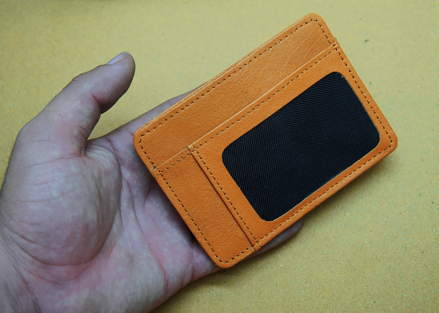 "Orange leather wallet with a modern design – ideal for professionals and trendsetters."