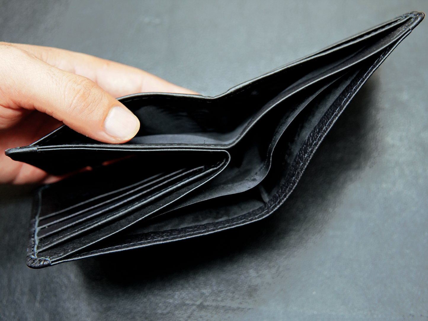 Inside view of Bovidas black bifold wallet showing 3 cash compartments