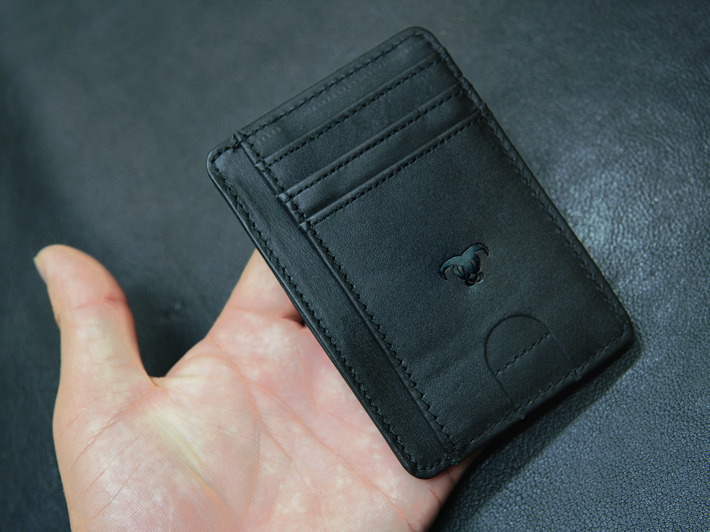 Slim black leather wallet in hand – perfect for minimalist everyday carry"