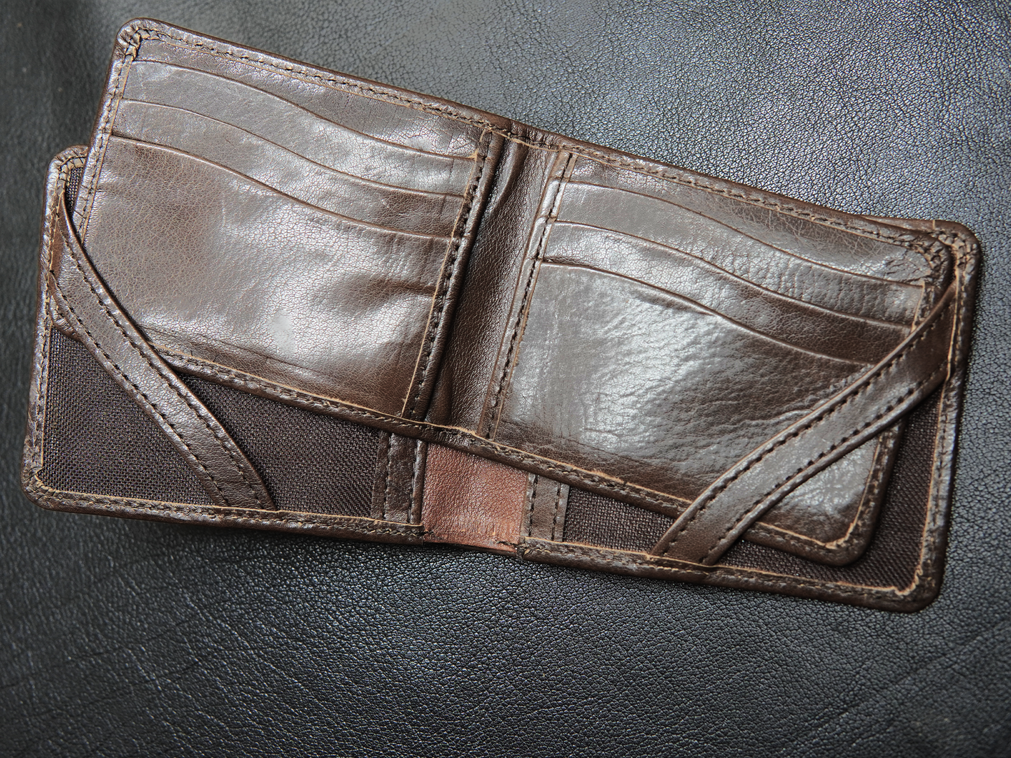 Close-up of hidden pockets beneath card slots inside FoldClassic leather wallet