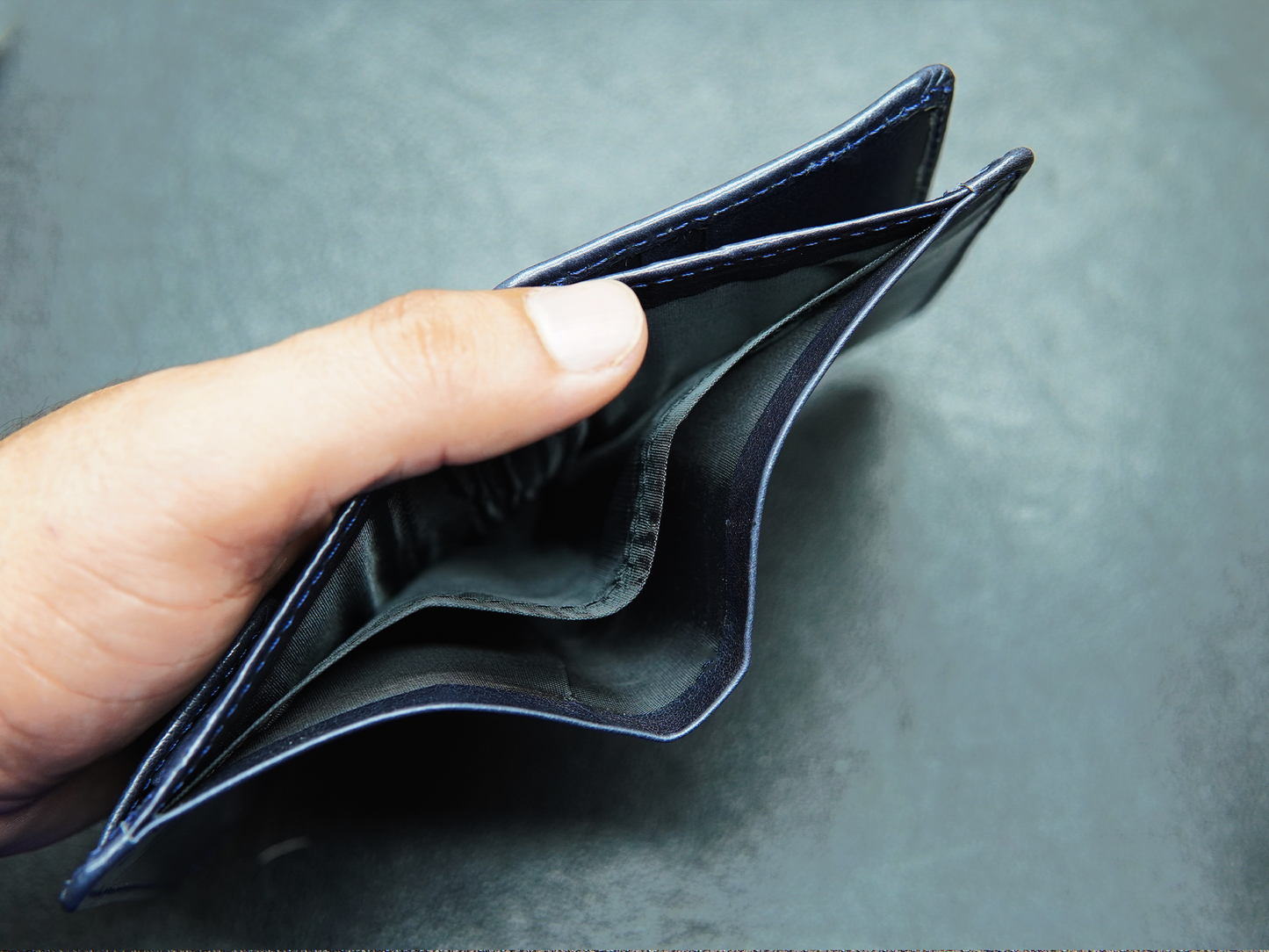 Open blue leather wallet with dual full-length cash compartments"