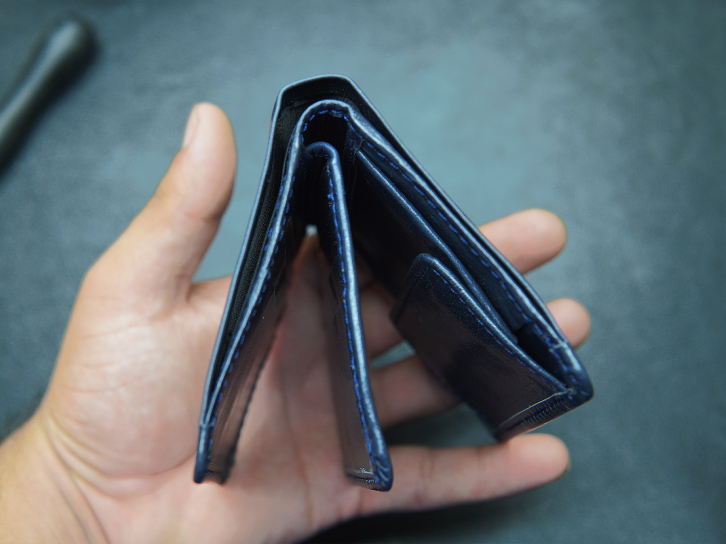 Open blue leather wallet with full-length cash compartments"