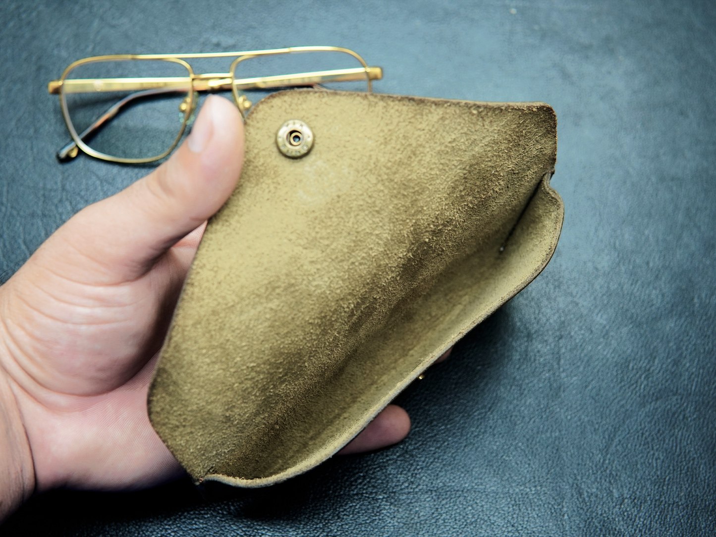 LensGuard leather glasses cover held open in hand showing fit and interior padding