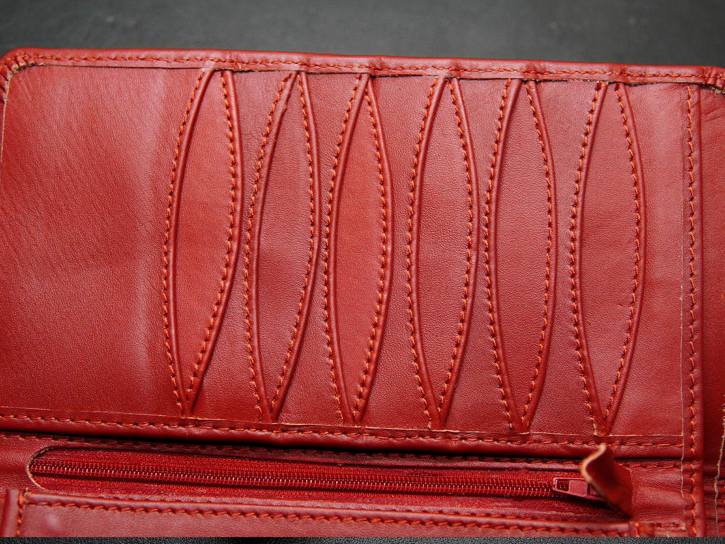 Close-up of a red leather wallet with visible stitching