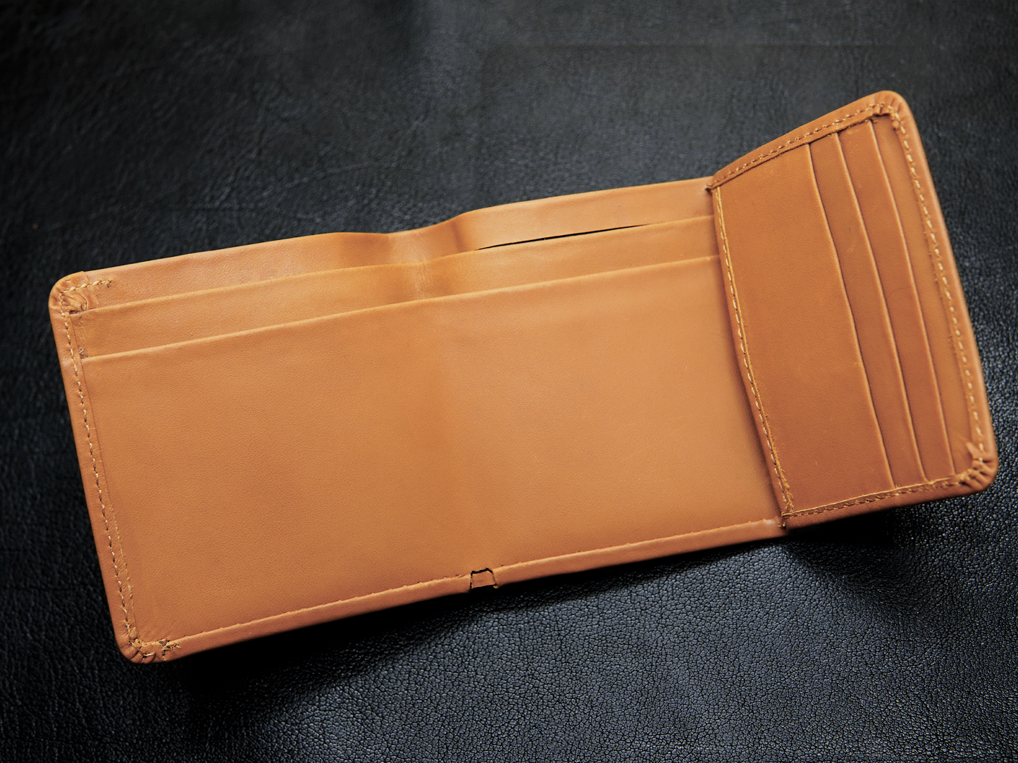 Open view of trifold wallet showing 3 card slots, and dual cash compartments