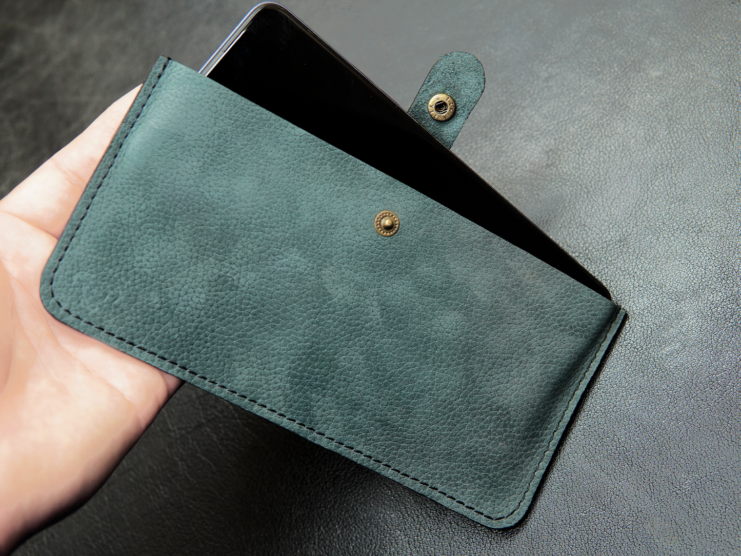 Bovidas Verde Pocket pouch held in hand showing compact size and fit