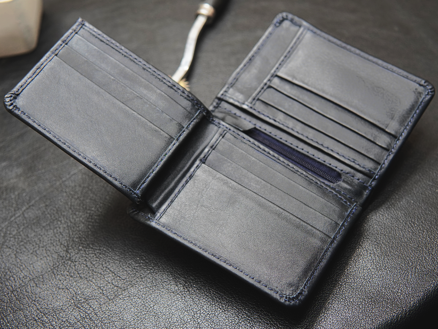 Black leather wallet with 12 card slots, zip compartment, photo slot, and cash compartment

