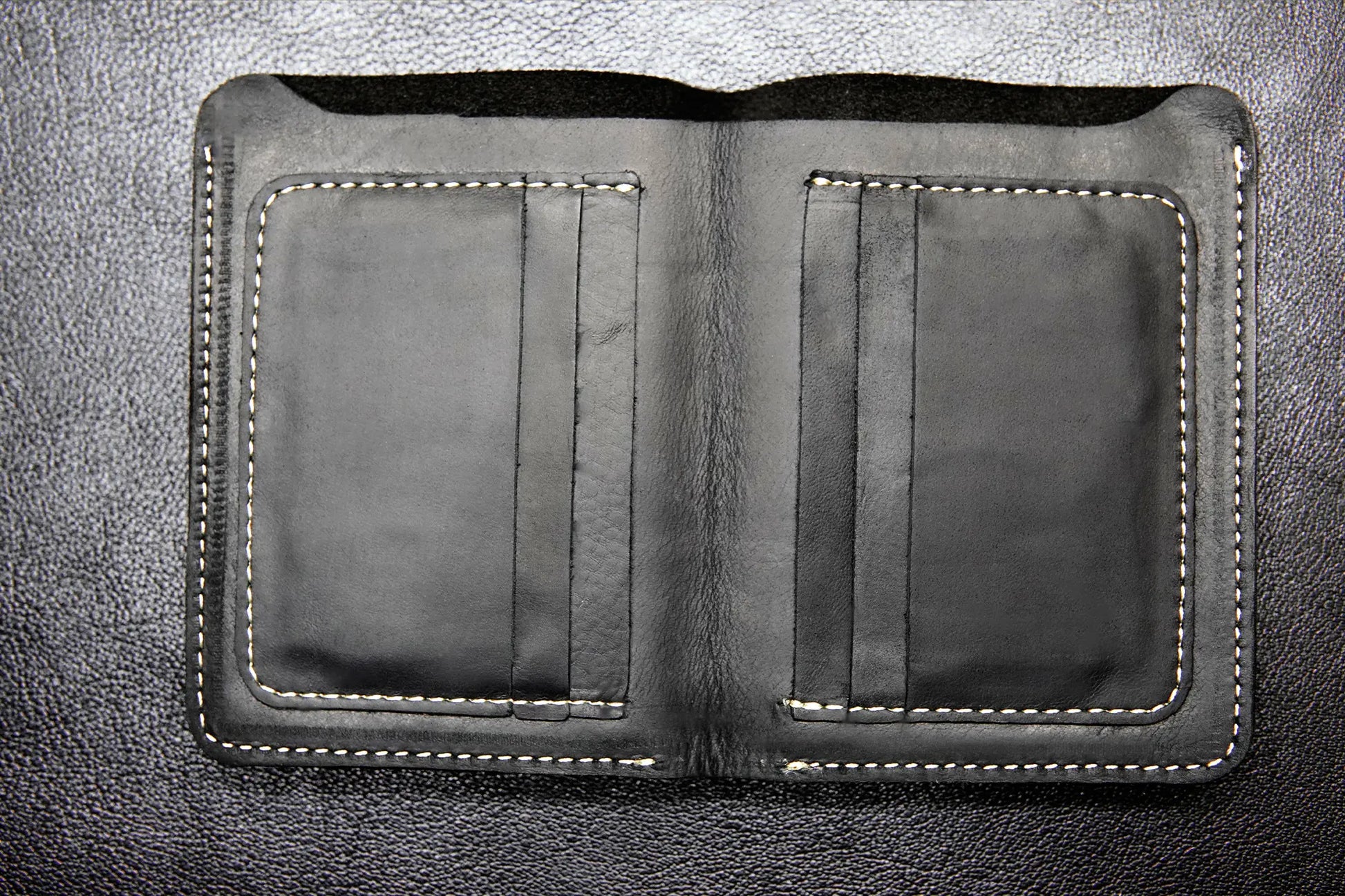 Black passport-size leather wallet with 6 card slots and a cash compartment


