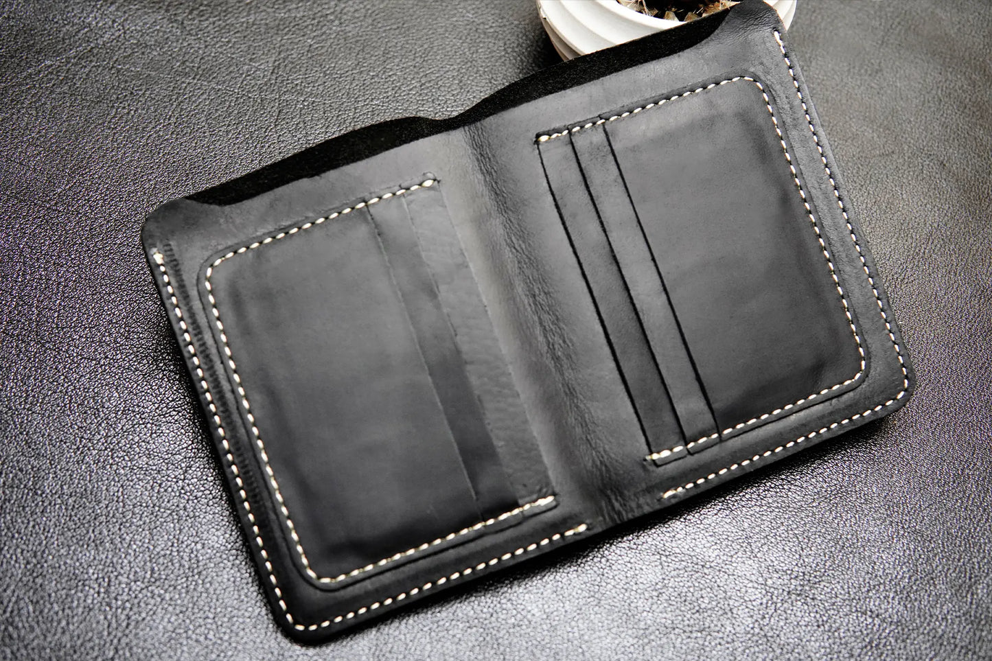 Black passport-size leather wallet with 6 card slots and a cash compartment

