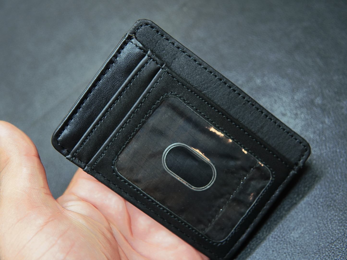 Slim black leather wallet in hand – perfect for minimalist everyday carry