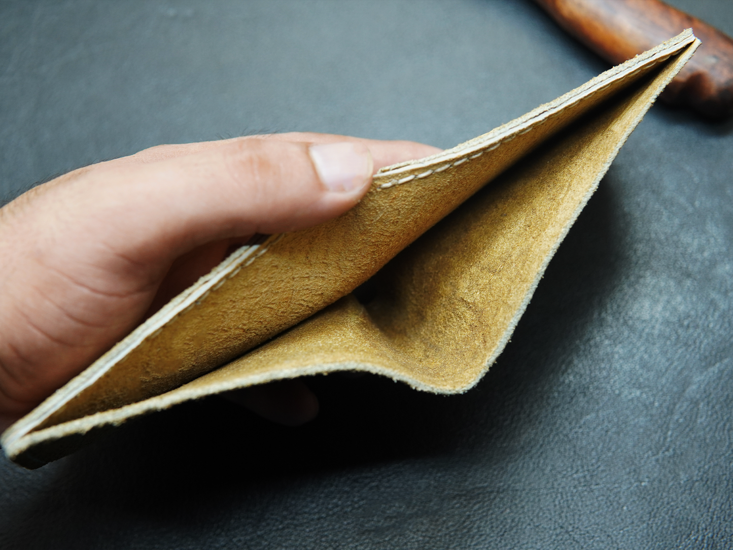 Hand holding a brown leather wallet 